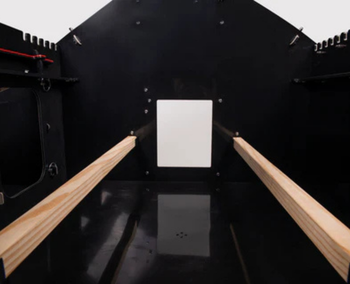 Inside view of Nestera Atlas chicken coop with two roosting bars and the coop door opening.