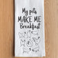 Kitchen towel with text 'My pets MAKE ME Breakfast' and chicken illustrations on a wooden surface